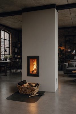 10-Ambio-Speicher_und-Grundofen Schlichter Grundofen mit schmaler Glasfront und Holzkorb in Loft-Wohnung